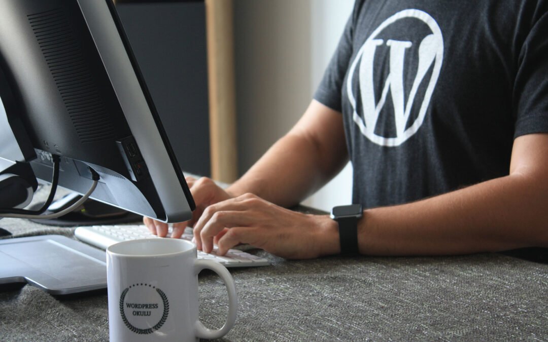 Photo représentant un web designer travaillant sous WordPress, logiciel qu'il apprécie car il porte un T-shirt à l'effigie de WordPress