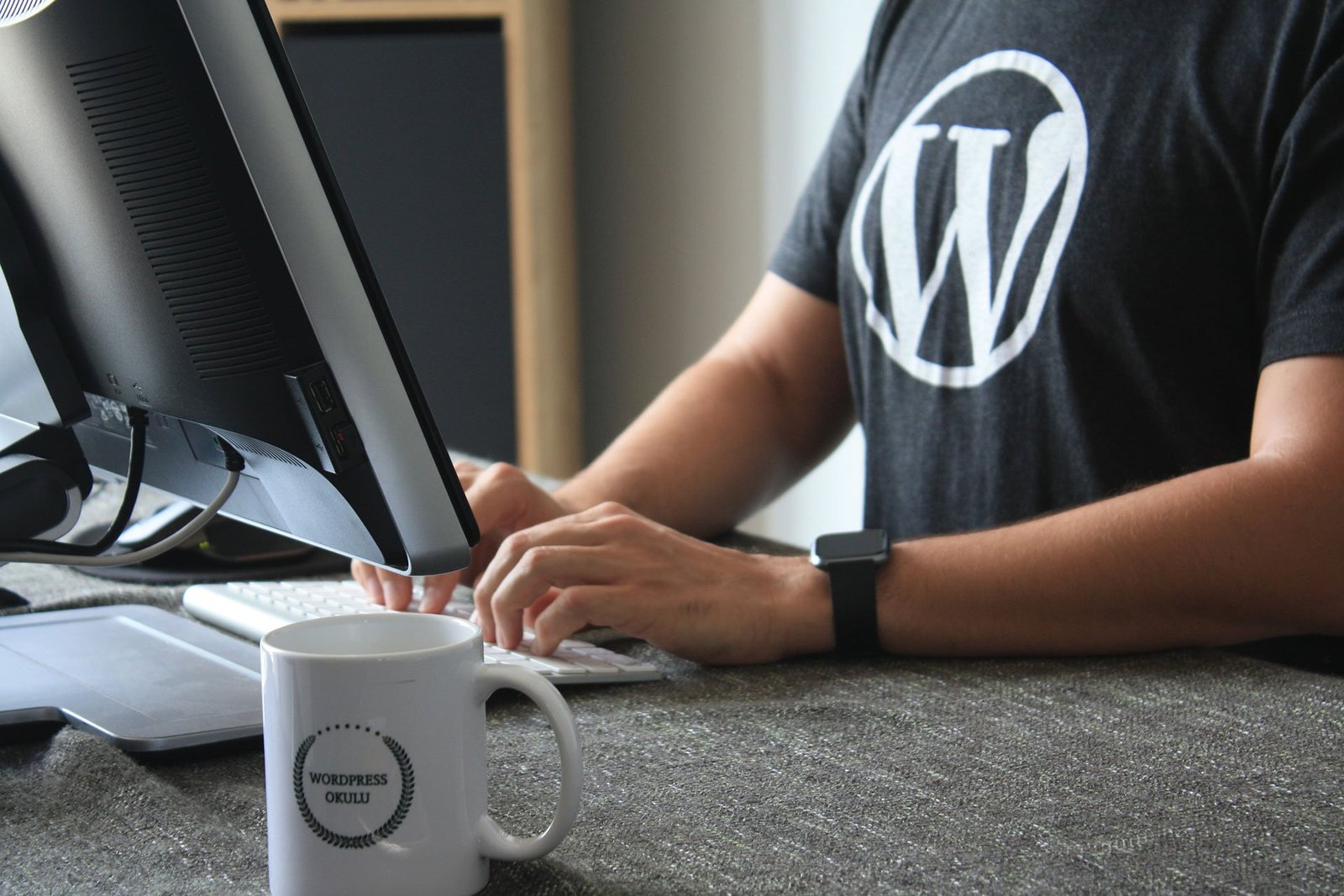Guide-web-design-responsive-WordPress-header Photo représentant un web designer travaillant sous WordPress, logiciel qu'il apprécie car il porte un T-shirt à l'effigie de WordPress