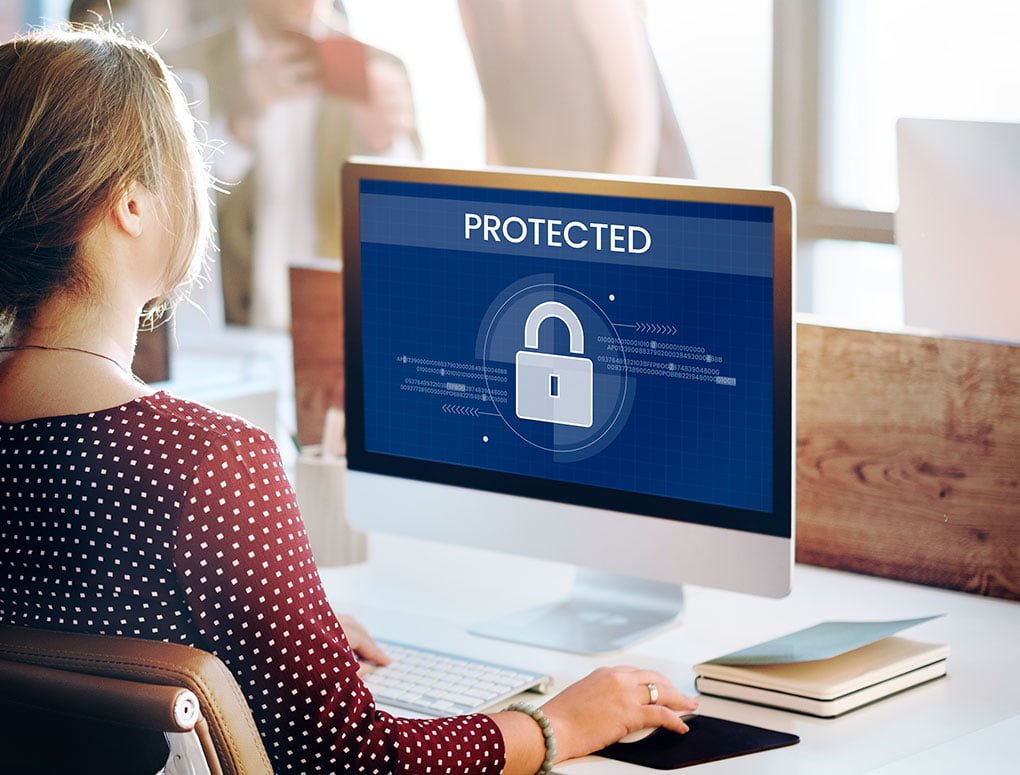 Photo représentant une femme travaillant sur un ordinateur affichant un cadenas et illustrant la nécessité de protéger les données personnelles des utilisateurs d'un site internet